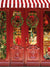 Festive Holiday Toy Store Photography Backdrop - Festive holiday toy store photography backdrop featuring a red storefront, Christmas wreaths, candy canes, and a toy window display.