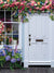 Floral Cottage Door Photography Backdrop - White cottage door adorned with colorful flowers, perfect as a photography backdrop for family and kids' photoshoots.