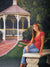 Lush green lawn with red and pink flower beds in a formal park setting.