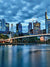 Frankfurt City Skyline Photography Backdrop - Frankfurt skyline during early evening with illuminated buildings reflecting on the river, featuring a sleek pedestrian bridge.