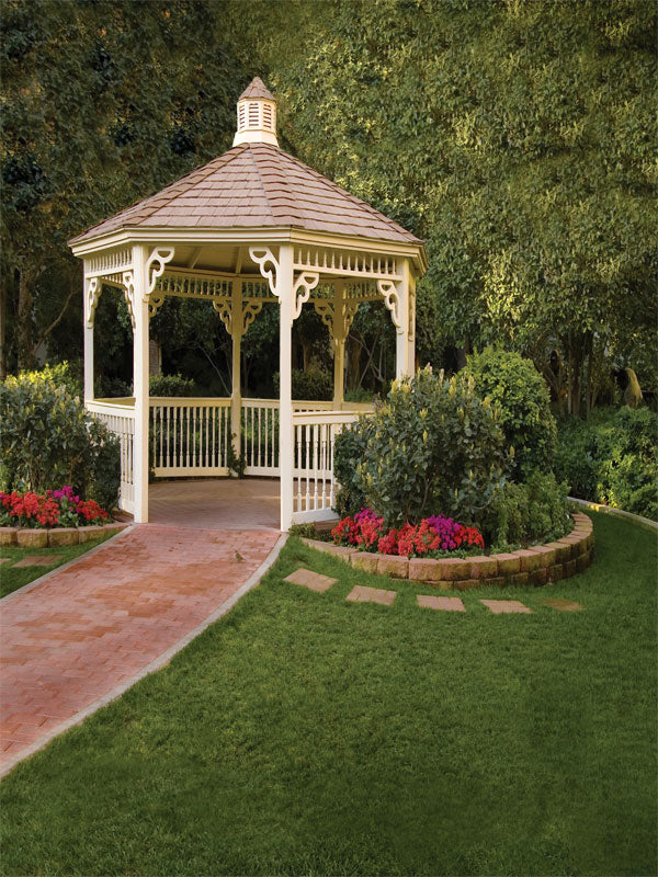 Elegant white gazebo surrounded by colorful flowers and a curved brick path.