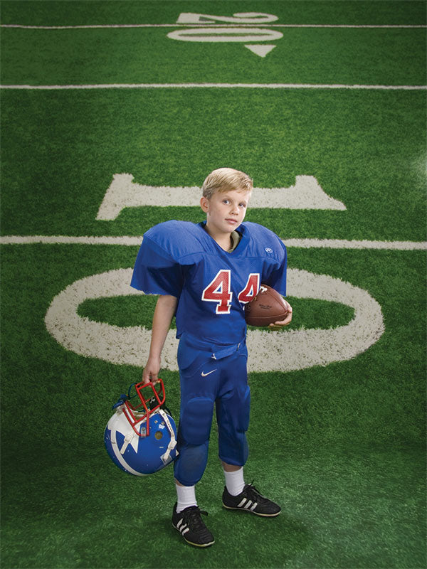 Studio backdrop simulating a football field with detailed yard markings.