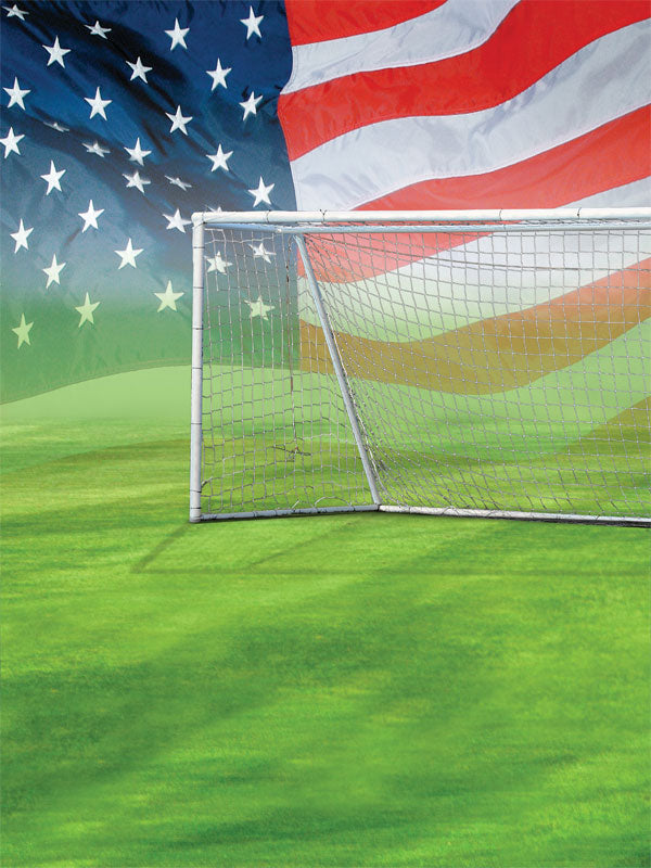 A soccer field photography backdrop featuring a white goalpost and a large American flag across the sky in the background.
