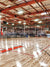 Indoor Basketball Court Backdrop - Spacious indoor basketball gym with polished wooden floors, multiple hoops, and industrial lighting.