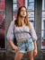 Full-body senior portrait setup with textured red brick and concrete window frame—great for studio photo shoots.