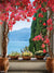 Mediterranean Garden Photography Backdrop - A Mediterranean garden terrace with red bougainvillea, lush greenery, and a view of the sea, ideal as a photography backdrop.