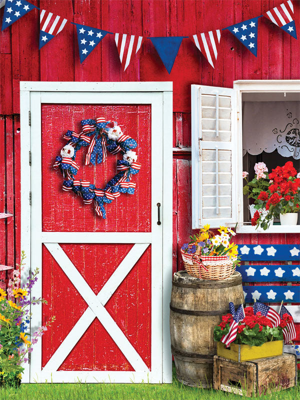 Patriotic Barn Door Photography Backdrop - Patriotic barn door photography backdrop with a red barn door, American flag decorations, and flower arrangements for festive photoshoots.