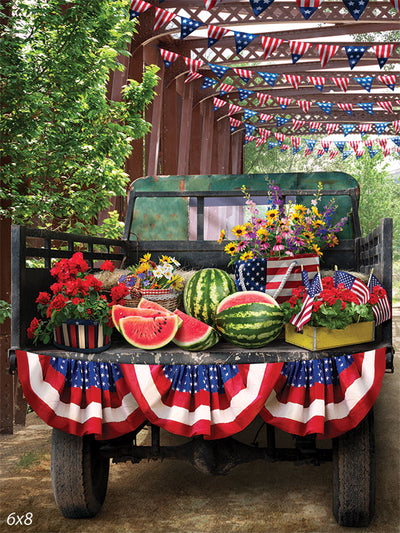 Patriotic Pickup Truck Watermelon Backdrop - Patriotic pickup truck filled with watermelons, flowers, and bunting under a canopy of American flags for a festive photography backdrop.