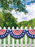 Patriotic White Picket Fence Photography Backdrop - Patriotic white picket fence photography backdrop with red, white, and blue bunting against a lush green forest setting.