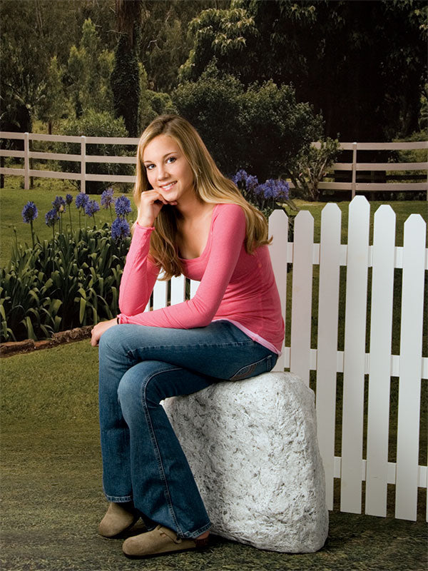 Peaceful outdoor scene with blooming flowers and rustic fence.