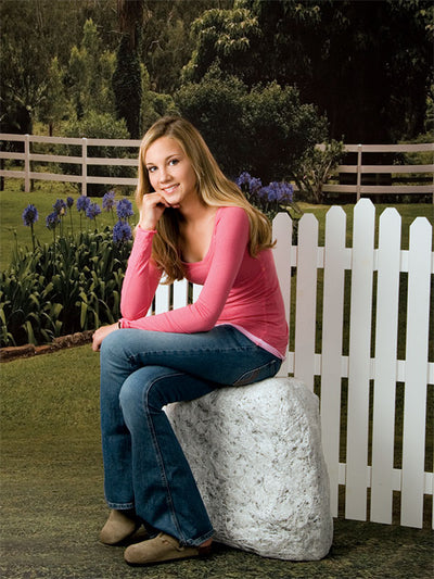 Peaceful outdoor scene with blooming flowers and rustic fence.