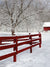 Red Barn Snowy Fence Photography Backdrop - Photography backdrop featuring a snowy winter scene with a red rustic fence, snow-covered tree branches, and a red barn in the background.