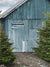 Rustic Blue Barn Holiday Photography Backdrop - Rustic blue barn photography backdrop with green pine trees, ideal for holiday and winter-themed photoshoots.