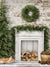 Rustic Fireplace and Pine Wreath Photography Backdrop - Rustic Christmas backdrop with a whitewashed fireplace, pine wreath, and Christmas tree for holiday photoshoots.