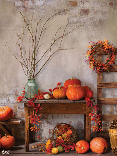 Rustic Harvest Photography Backdrop - A rustic autumn harvest photography backdrop featuring a wooden table with pumpkins, fall leaves, a wreath, and a textured wall.