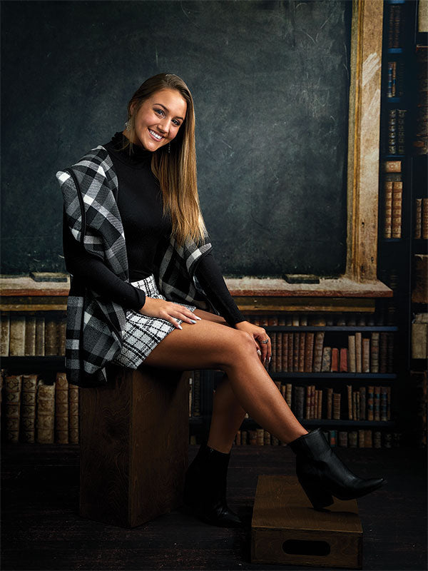 A vintage-style photography backdrop showcasing a rustic wooden chalkboard framed by antique bookshelves filled with aged tomes.