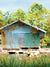 Rustic River Shack Photography Backdrop - Rustic river shack backdrop with teal, brown, and rust tones, set by a peaceful river for country-themed photoshoots.