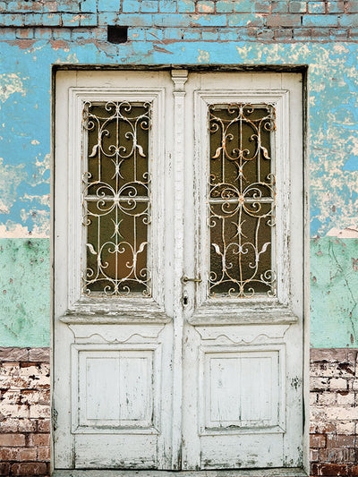 Rustic Vintage Door Photography Backdrop - Photography backdrop featuring a rustic wooden door with wrought iron details and a distressed pastel-colored wall, ideal for vintage-themed photoshoots.