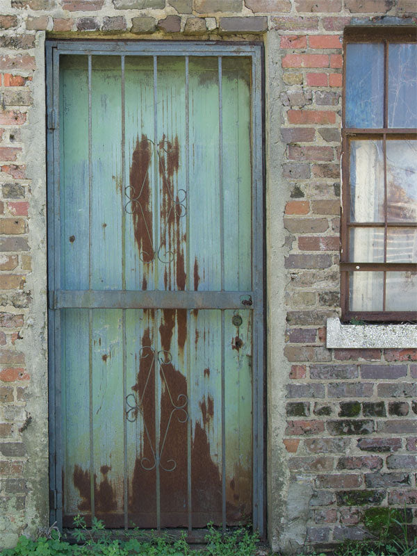 Rustic Weathered Door Photography Backdrop - Rustic photography backdrop featuring a weathered metal door in a brick wall setting, ideal for themed and industrial photoshoots.