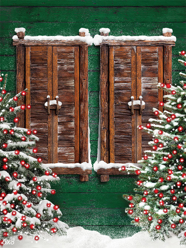 Rustic Wooden Shutters Christmas Photography Backdrop - Rustic wooden shutters surrounded by snow-covered evergreens with red Christmas lights, perfect for holiday photography backdrops.