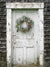 Rustic Wreath Cottage Door Photography Backdrop - Rustic weathered cottage door with a holiday wreath, designed as a photography backdrop for festive or winter-themed photoshoots.