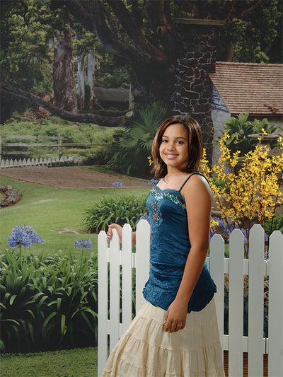 Backdrop featuring a stone chimney cottage surrounded by vibrant greenery and a winding path.