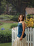 Backdrop featuring a stone chimney cottage surrounded by vibrant greenery and a winding path.