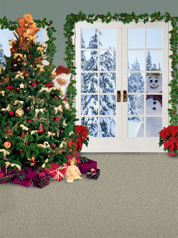 A festive indoor Christmas photography backdrop with Santa and a snowman peeking through a snowy window behind a decorated tree.