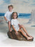 A tranquil beach scene backdrop capturing rolling waves, a bright sky, and natural dune grass.