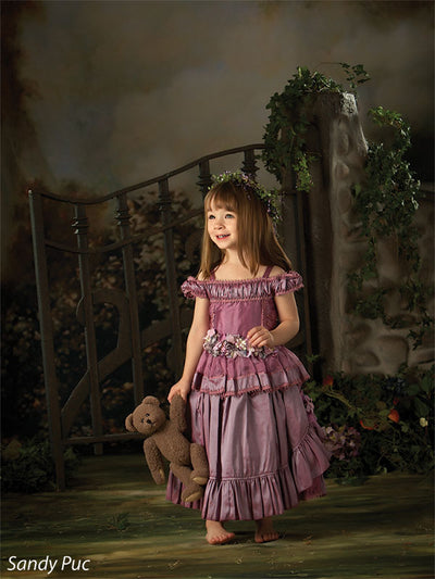 A photography backdrop with intricate sculpture details framed in moody garden shadows.