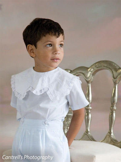 Close-up of a boy in formal attire against pastel painted floral backdrop—great for classic child portraits and heirloom photos.