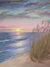 Serene beach scene with pink and yellow sunset, calm waves, and tall sea oats in the foreground.
