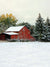 Snowy Barn Holiday Photography Backdrop - Rustic red barn in a snowy field with pine trees in the background, ideal for holiday and winter photography backdrops.