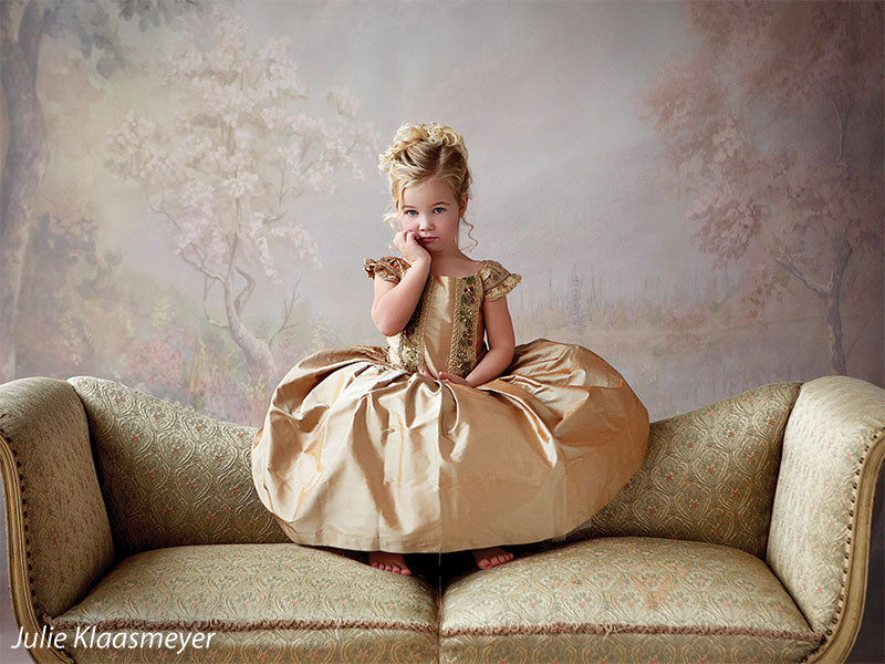 Printed backdrop with impressionist florals, trees, and a subtle, hazy sky.