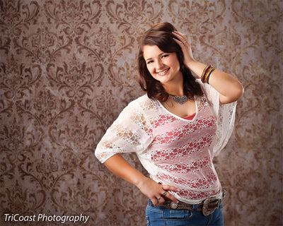Teen girl poses confidently in front of an aged gold damask backdrop with distressed texture—ideal for senior portraits, school photography, and traditional full-length studio portraits.