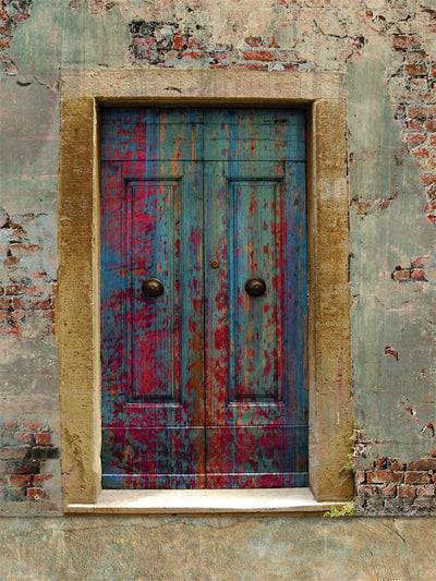 Vintage blue door with a weathered frame against a rustic, aged wall background for professional photography sessions.