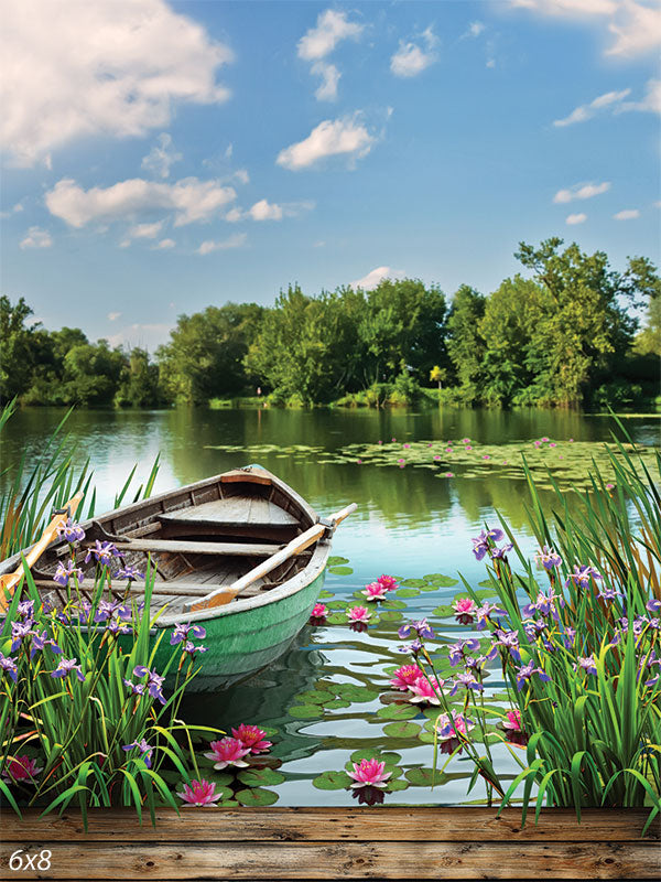 Tranquil Lake with Boat Photography Backdrop - Tranquil lake with boat photography backdrop featuring water lilies, green reeds, and a tree-lined shore.