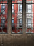 Urban Brick Window View Backdrop - Photography backdrop of urban brick building seen through industrial-style windows with fire escapes.