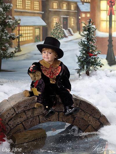 Gas lamp and snowy path near warmly lit storefront with Christmas wreath.