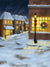 Festive winter street with Christmas tree and vintage gas lamps.