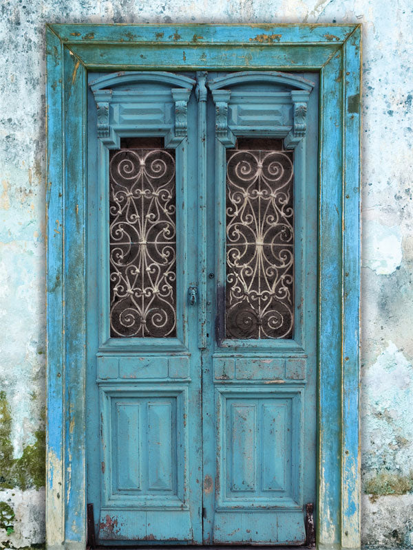 Vintage Blue Wooden Door Photography Backdrop - A rustic, distressed blue wooden door backdrop with intricate wrought iron details, perfect for vintage-themed photoshoots.