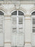 Vintage Colonial Shutter Photography Backdrop - A vintage colonial shutter photography backdrop with soft white and pale gray tones, featuring weathered wood shutters and stately columns.