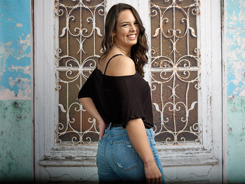 A Mediterranean-style photography backdrop featuring an aged wooden door with pastel hues and intricate wrought iron detailing.