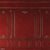 A vintage-style deep red photography backdrop with intricate gold detailing, perfect for classic portrait photography.