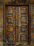 Rustic wooden double doors with a weathered finish and moss accents, offering a vintage charm for professional photography setups.