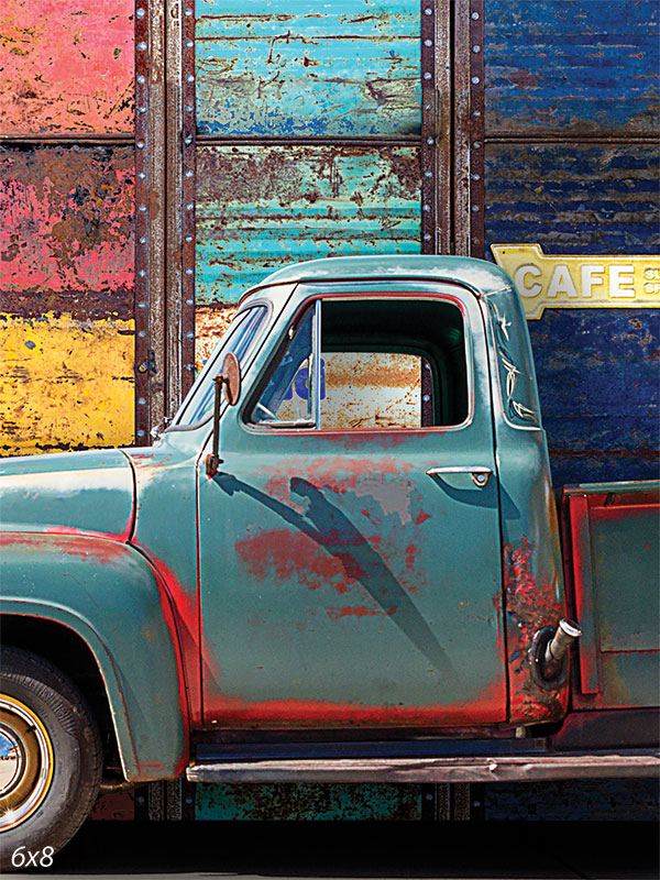 Vintage Truck with Colorful Garage Door Backdrop - Photography backdrop featuring a teal-colored vintage truck in front of a weathered, multicolored garage door.