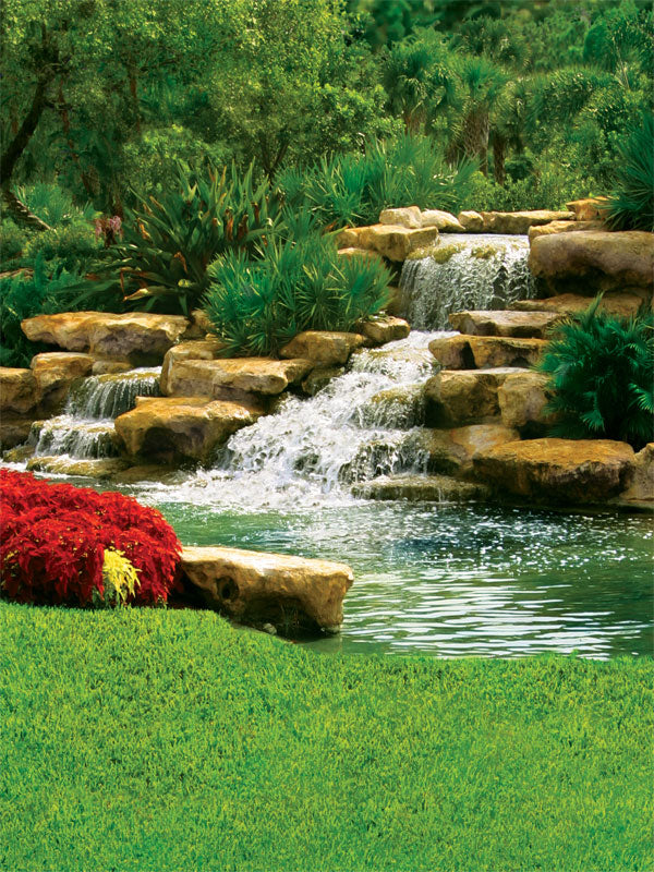 A tranquil photography backdrop featuring a cascading waterfall, natural rock formations, and lush green foliage for an immersive outdoor scene.
