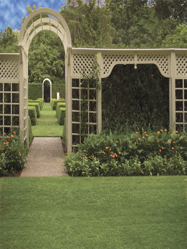 A garden photography backdrop featuring a white trellis arbor and pathway lined with manicured green hedges.