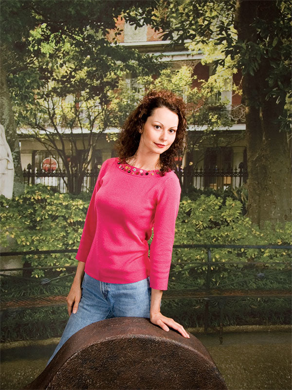 Photography backdrop with a black iron bench in a lush garden, framed by tall trees and greenery.