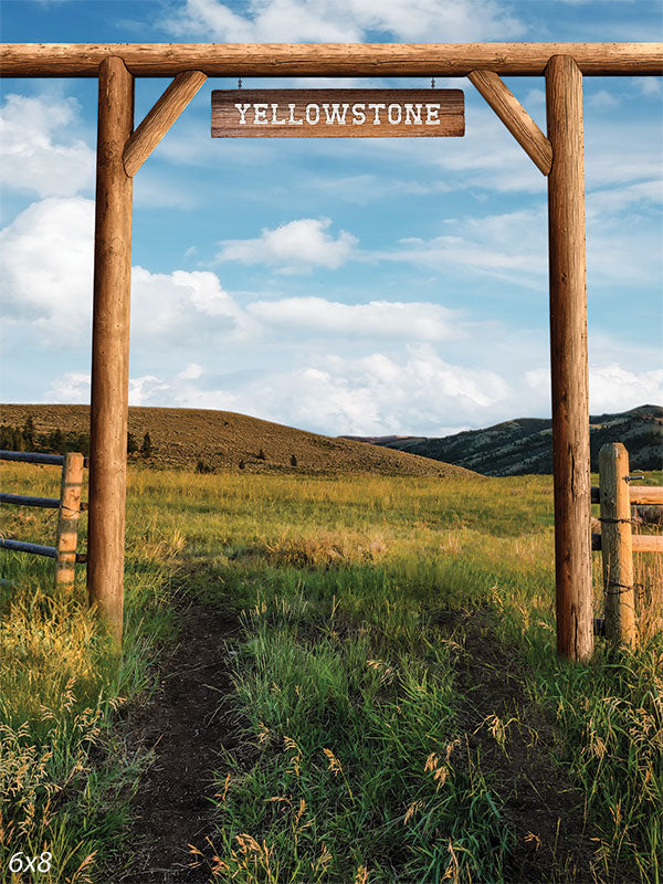 Yellowstone Ranch Photography Backdrop - Photography backdrop featuring a rustic ranch gate with Yellowstone sign set against a grassy field and blue sky.